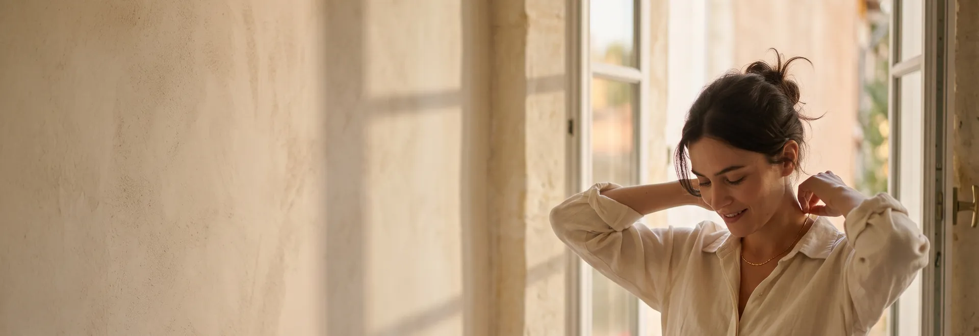 The ALVANY boutiques: a woman at a tall window in the first warm light of the day