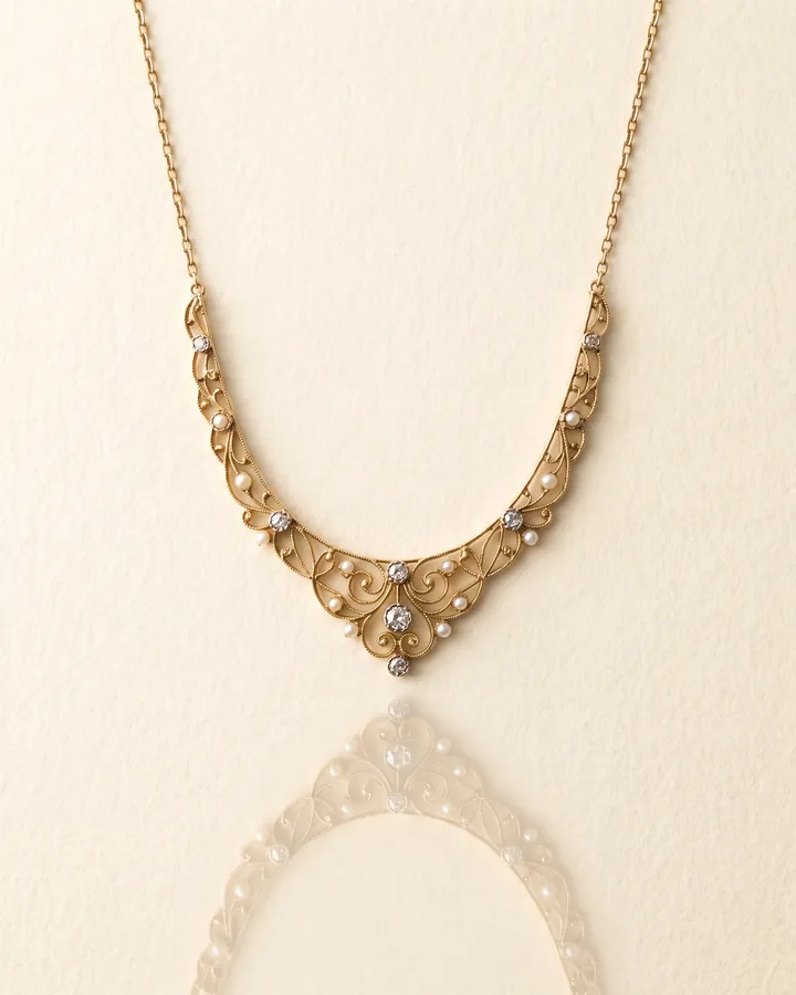 A gold necklace photographed flat on warm paper for the ALVANY press desk